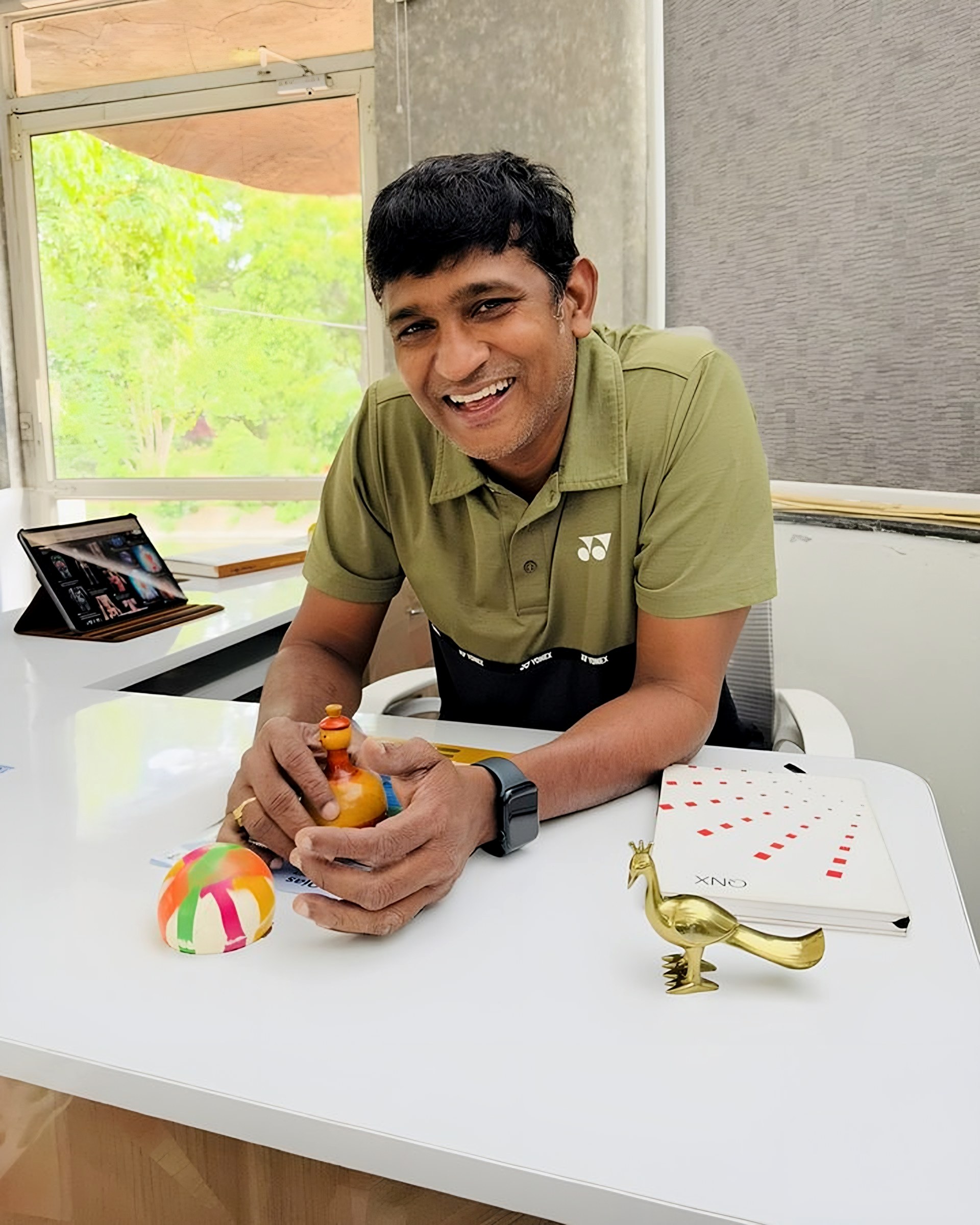 Lomada Raju smiling at his desk