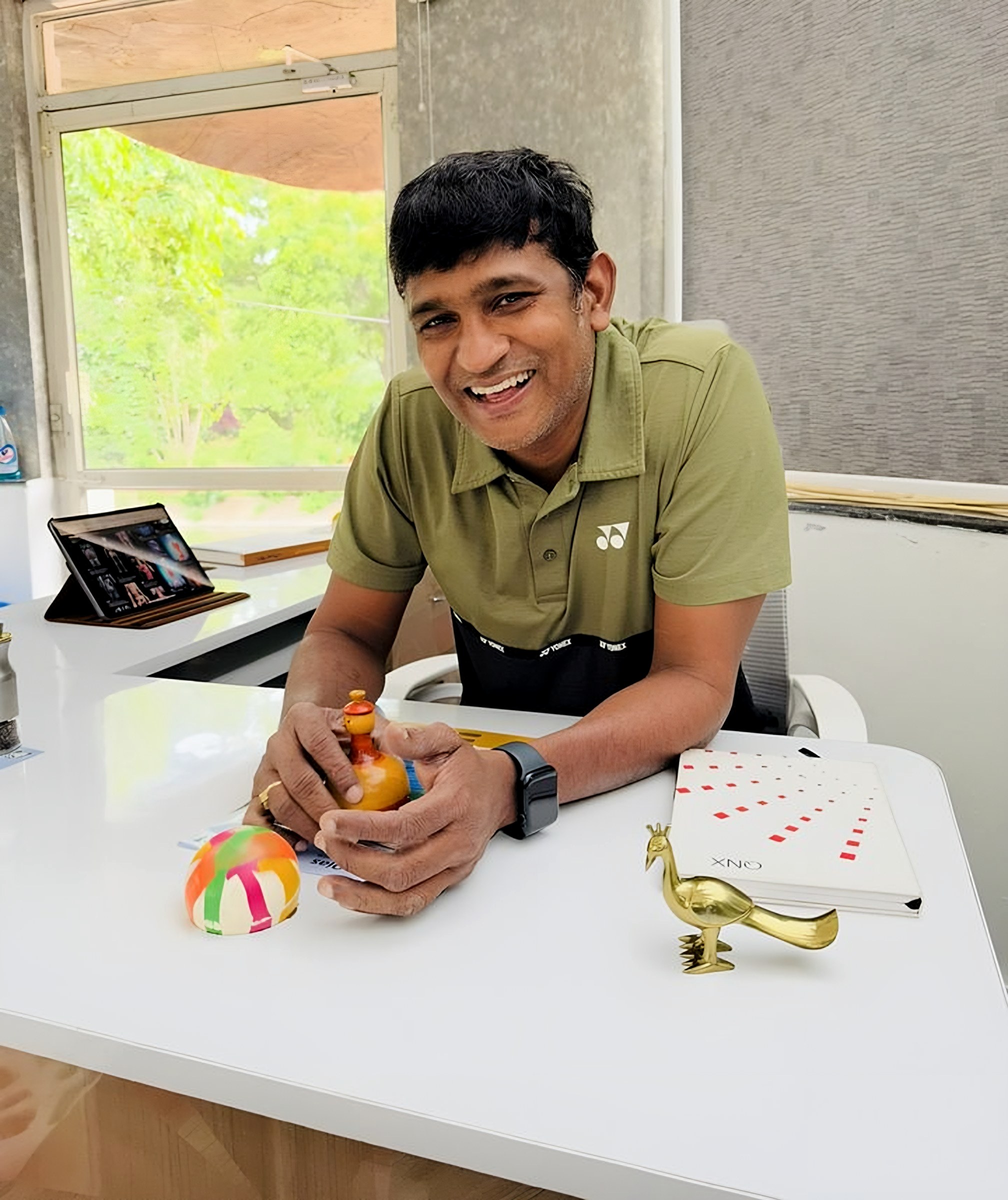 Lomada Raju laughing at his desk